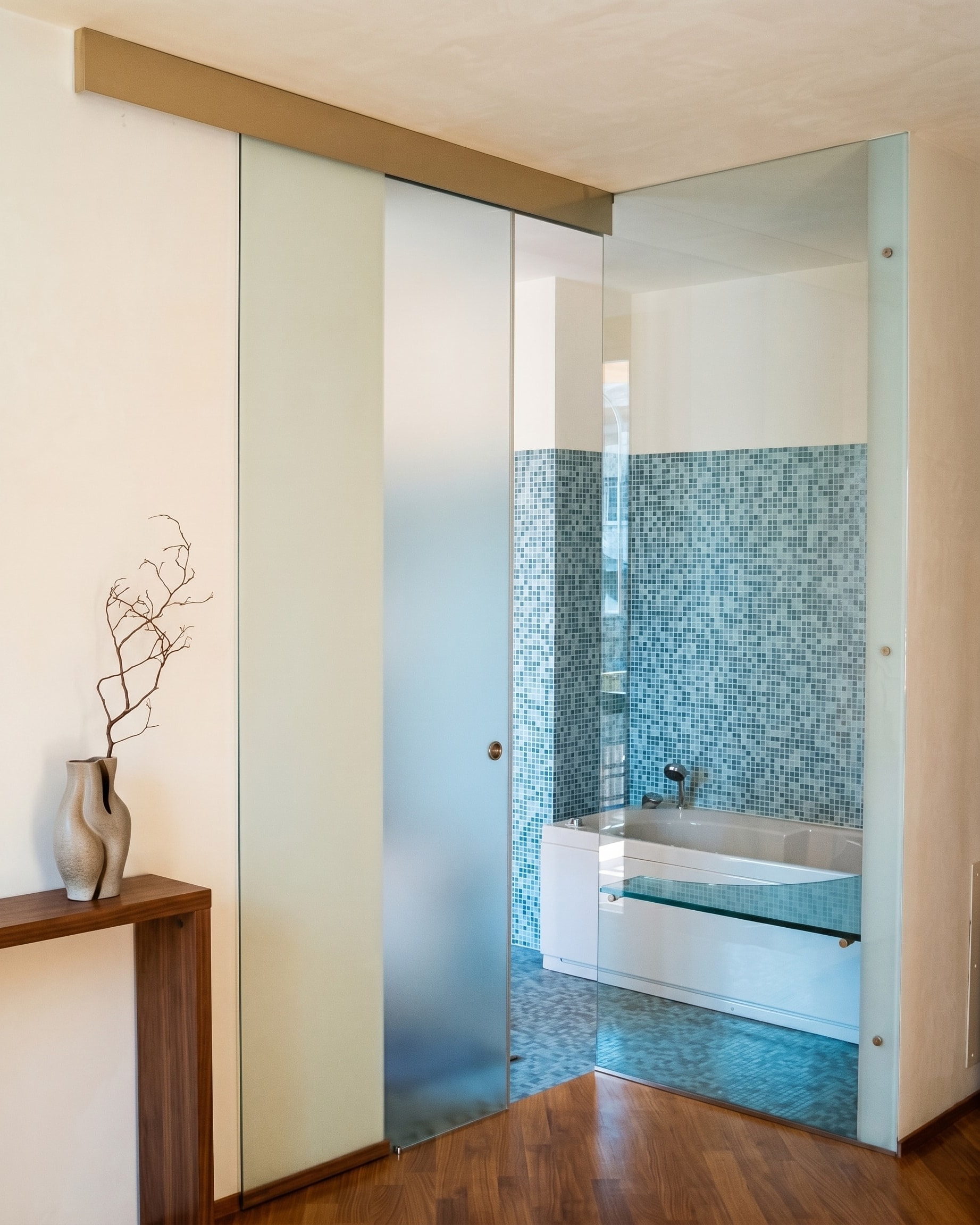 Porta scorrevole in vetro satinato verso un ambiente bagno